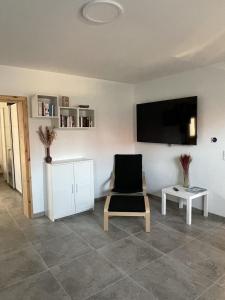 un soggiorno con sedia e TV a schermo piatto di Port007 a Priepert