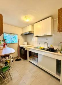 une cuisine avec des armoires blanches et un comptoir dans l'établissement Elegant Home, boasting sweeping sea !, à Wilderness