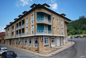 um grande edifício de tijolos ao lado de uma rua em Hotel Águila Real em Cangas de Onís