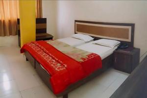 纳西克Hotel Saffronn的卧室里有一张大床，上面铺着红毯子