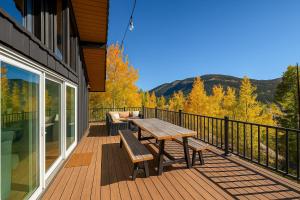 a deck with a wooden table and bench on a house at The Golden Moose Chalet in Grand Lake