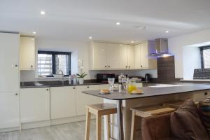 a kitchen with white cabinets and a table with chairs at Cider Mill in Bullingham