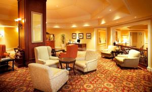 a lobby with couches and chairs and a table at Southern Sun Bloemfontein in Bloemfontein