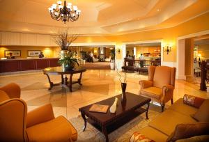 a lobby with couches and chairs and a table at Southern Sun Bloemfontein in Bloemfontein