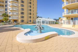 a swimming pool with a statue in front of a building at Beach Colony Tower 7A By Pkrm in Pensacola