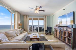 a living room with a couch and a table at Beach Colony Tower 7A By Pkrm in Pensacola