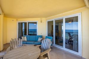 a living room with a couch and a table and chairs at Beach Colony Tower 7A By Pkrm in Pensacola
