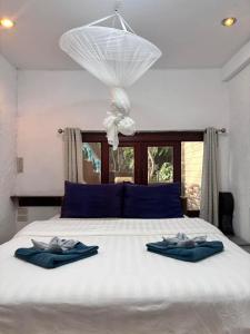 um quarto com uma cama com duas toalhas azuis em Sense Asia em Haad Tian