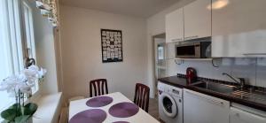 eine Küche mit Tisch, Spüle und Mikrowelle in der Unterkunft City Apartment Sairaalakatu, lämmin sähköistetty autotalli sisältyy hintaan in Kuopio + 20 Fotos