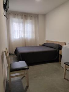 Un dormitorio con una cama, una silla y una ventana en Pension La Puntica, en Lo Pagán 26 fotos más