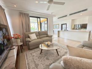 a living room with two couches and a table at The Palms at Waterfront in Darwin