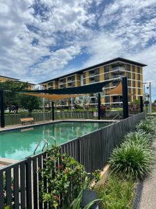 a swimming pool in front of a building at The Palms at Waterfront in Darwin