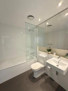 a white bathroom with a toilet and a sink at The Palms at Waterfront in Darwin +11 photos