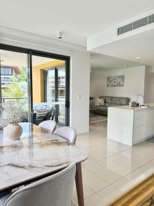 a kitchen and living room with a table and chairs at The Palms at Waterfront in Darwin