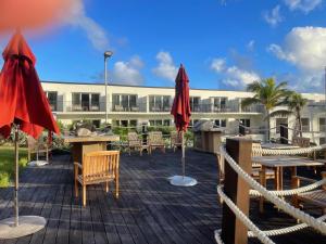 Un patio con mesas y sombrillas frente a un edificio. en Dawn Beach JW Marriott, en Oyster Pond