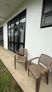 zwei Stühle und ein Stuhl neben einem Gebäude in der Unterkunft Priima in Ahangama