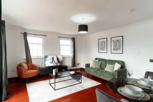 un soggiorno con un divano e un tavolo di Bright 1 Bed Harbour-side Apartment with Balcony a Whitehaven Altre 10 foto