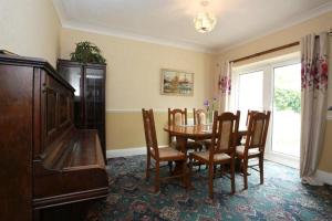ein Esszimmer mit einem Tisch, Stühlen und einem Klavier in der Unterkunft Bournemouth Holiday Home in Southbourne