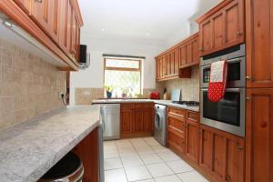 eine Küche mit Holzschränken und einer Arbeitsplatte in der Unterkunft Bournemouth Holiday Home in Southbourne