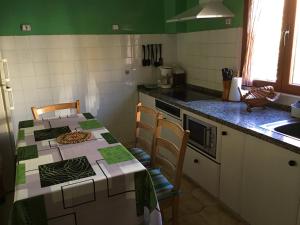 Casa de alquiler turístico en León centro - 6 plazas في ليون: مطبخ مع طاولة مع كرسيين ومغسلة