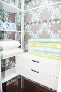 a closet with white drawers and wallpaper at Putra Villa Short Stay Apartment KL in Kuala Lumpur