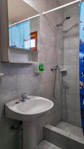 um banheiro com pia e chuveiro em Apartamentos Matices em El Calafate mais 87 fotografias