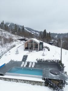 a house with a swimming pool in the snow at Rest Hub in Slavske
