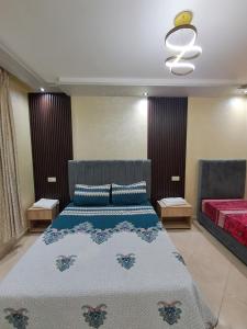 Un dormitorio con una cama con un edredón azul. en اقامة تورارن, en Yebha 3 fotos más