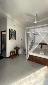 a bedroom with a bed with a canopy and a table at Priima in Ahangama +38 photos