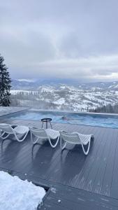 a table and a bench on a deck with snow at Rest Hub in Slavske