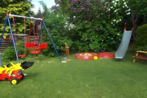 un cortile con un mucchio di attrezzature per il parco giochi nell'erba di Haus Wacholderheide a Onstmettingen