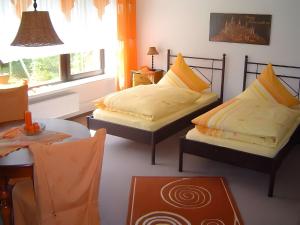 due letti seduti in una stanza con un tavolo e un tavolino di Haus Wacholderheide a Onstmettingen