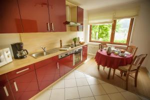 una cucina con un tavolo con una tovaglia rossa di Haus Wacholderheide a Onstmettingen