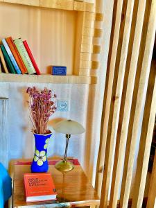 a table with a lamp and a vase with books at The Secret Garden House in Ijevan