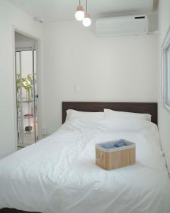a white bed with a wooden box on it at 부산 광안리 B&B stay in Busan
