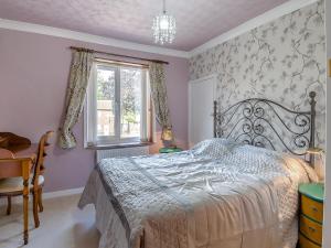 a bedroom with a bed and a table and a window at Ravensmere Villa in Beccles