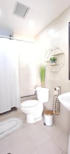 een witte badkamer met een toilet en een wastafel bij Chillis Penthouse in Porlamar +9 foto's