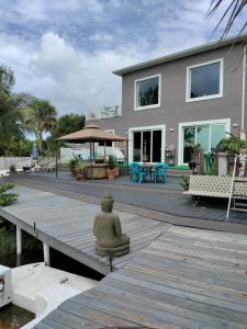 Eine Steinstatue steht auf einer Holzterrasse vor einem Haus. in der Unterkunft The Beach House Zen Place Luxury Amazing Views in Naples