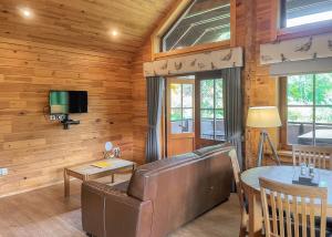 InchmillにあるGlen Clova Lodgesのソファとテーブルのあるリビングルーム