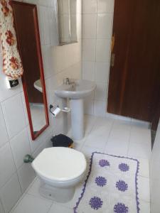 a bathroom with a toilet and a sink at Chacara araujo in Mairiporã +3 photos