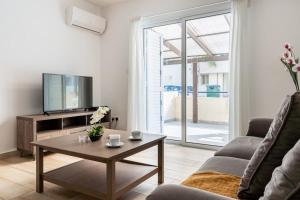 a living room with a tv and a coffee table at Levante - 2-BR Apt & Terrace in Larnaca in Larnaka +19 photos