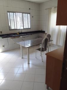 a kitchen with a table and two chairs in it at Chacara araujo in Mairiporã