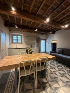 een keuken met een grote houten tafel en stoelen bij BORGO COMPAGNIA il Calzolaio in Castiglion Fibocchi
