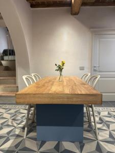 een vaas met bloemen op een houten tafel in een kamer bij BORGO COMPAGNIA il Calzolaio in Castiglion Fibocchi +10 foto's