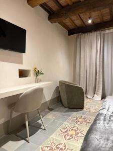 een slaapkamer met een bureau, een stoel en een televisie bij BORGO COMPAGNIA il Calzolaio in Castiglion Fibocchi