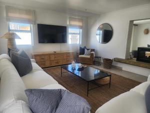 a living room with a white couch and a coffee table at White Wicker House in Langebaan