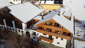 an aerial view of a building with snow covered roofs at Zalnerhof Urlaub am Bauernhof in Luson