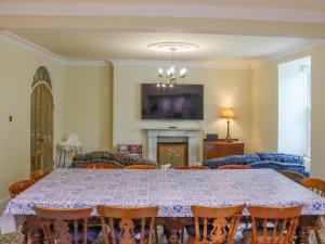 d'une salle à manger avec une table, des chaises et une télévision. dans l'établissement Hafod Grove - Ukc6955, à Moylgrove