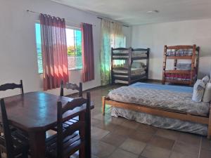 伊塔尼亚恩Loft Praia do Sonho的一间卧室，里面有一张床、一张桌子和几把椅子。