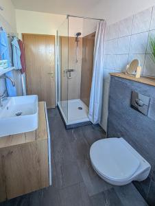 a bathroom with a toilet and a sink and a shower at Refugium - Möhneseeblick in Möhnesee +10 photos